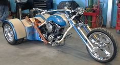 a blue and white motorcycle parked in a garage next to other tools on the floor