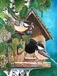 two birds sitting on top of a bird house