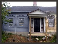 an old house with boarded up windows and wooden steps leading to the front door is shown