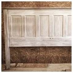 an old white headboard with wooden paneling in a room that is being remodeled