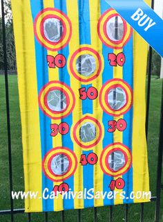 an image of a carnival game on the fence in front of some grass and trees