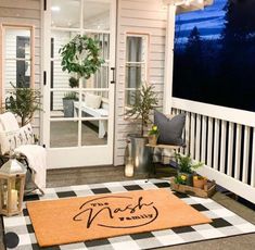 the porch is decorated with potted plants and decorations, including a welcome mat that says north bend