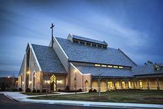 a large church lit up at night with lights on the front and side of it