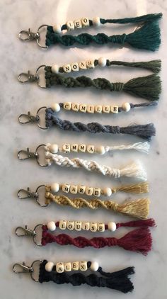 six tasseled keychais with white beads on them