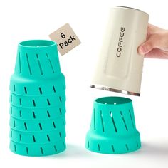 a hand holding a coffee cup next to a stack of cups with the words 6 pack on them