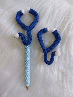 two crocheted blue and white objects laying on top of a white fur covered surface