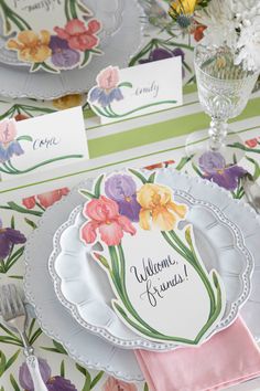 the table is set with flowers and place cards