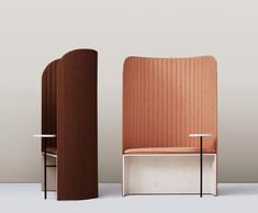 two chairs sitting next to each other in front of a wall