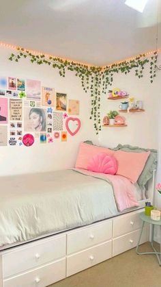 a bedroom decorated in pink and green with pictures on the wall