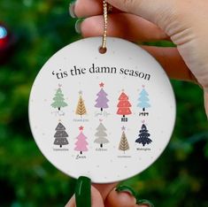 someone holding up a christmas ornament that says, it's the damn season