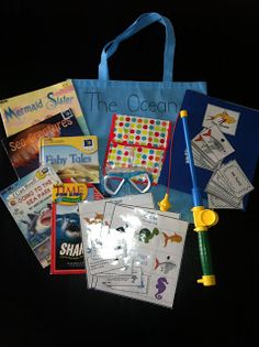 a blue bag filled with children's books and other items on a black background