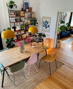 a dining room table with two chairs and a vase filled with flowers on top of it