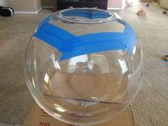 a clear glass bowl with blue tape on it sitting on top of a cardboard box