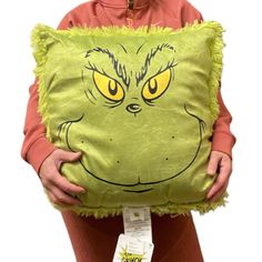 a person holding a pillow with an angry grin face on it