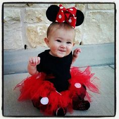 a baby girl wearing a minnie mouse outfit