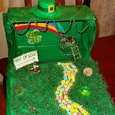 a cake made to look like a trunk with candy in it and a green hat on top