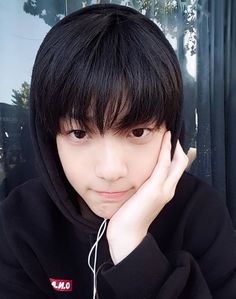 a young man with black hair wearing a hoodie