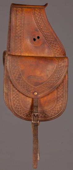 a brown leather saddle with a metal buckle on it's side and an intricately embossed design