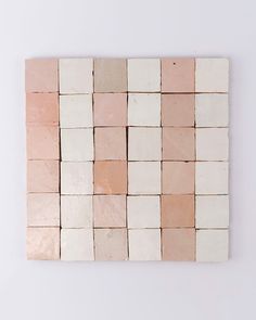 a white and pink tile wall hanging on the wall