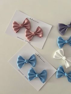 four different colored bows are on top of each other, one is blue and one is pink