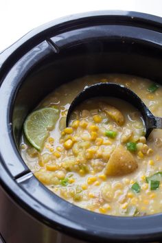 a close up of a bowl of food with a spoon in it and the words vegan potato corn chowder