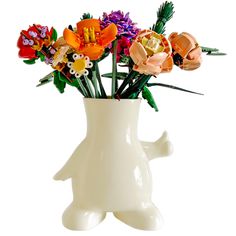 a white vase filled with lots of colorful flowers