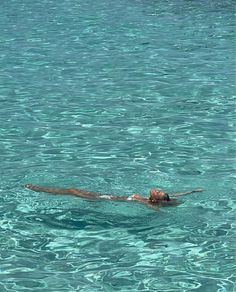 a dog swimming in the ocean with his head above the water's surface,