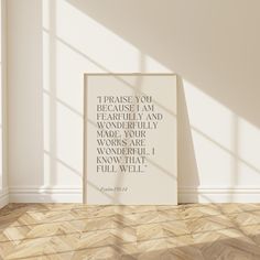 a white framed poster on the floor in an empty room with sunlight coming through it