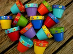 colorful plastic cups with flower designs on them sitting on top of a wooden table next to each other