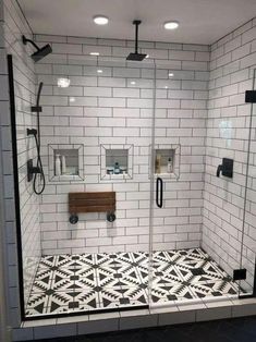 a bathroom with black and white tiles on the floor, shower head, and toilet