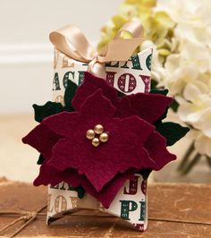 a gift wrapped in fabric and decorated with poinsettia