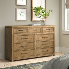 a bedroom with a dresser and pictures on the wall