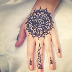 a woman's hand with henna tattoos on it