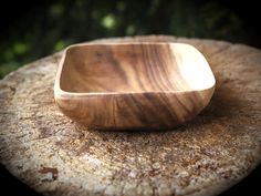 a wooden bowl sitting on top of a rock