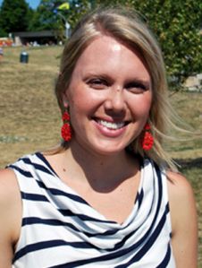 a woman in a striped shirt and red earrings