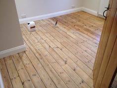 an empty room with hard wood floors and a paint roller on the floor next to it