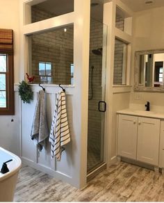 a bathroom with a walk in shower next to a bathtub and sink under a window