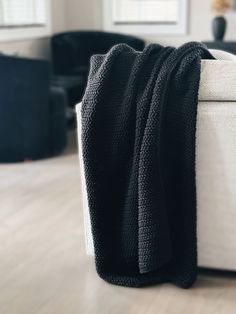 a white couch with a black blanket on it