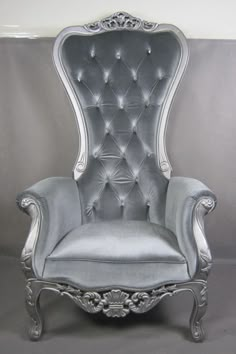 an old fashioned chair with silver velvet upholstered