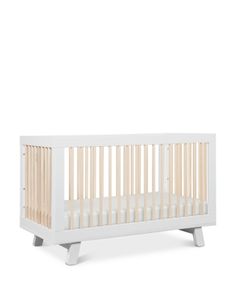 a white crib with wooden slats on the top and bottom, against a white background