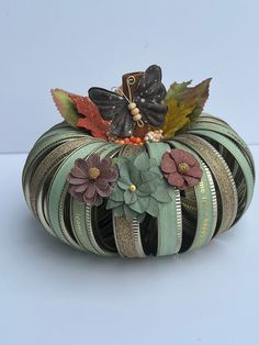 a decorative pumpkin decorated with leaves and flowers