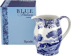 a blue and white porcelain pitcher next to a box for it's contents on a white background