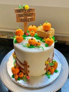 a birthday cake decorated with pumpkins and flowers