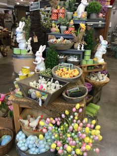 many baskets filled with different types of easter eggs and other decorations on display in a store