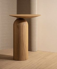 a wooden table sitting on top of a hard wood floor next to a white wall