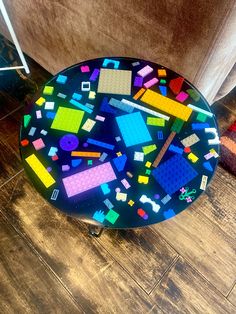 a table that has been made out of legos on top of wood flooring