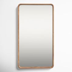 a wooden mirror hanging on the wall