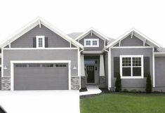 a gray house with white trim and two car garages in front of the house