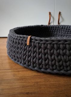 a gray basket sitting on top of a wooden floor