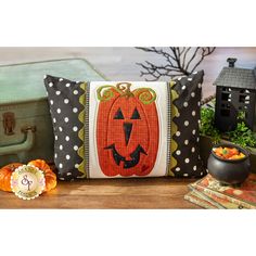 a pumpkin pillow sitting on top of a wooden table